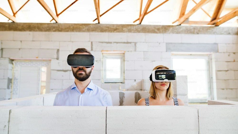 Joven pareja casada o arquitectos con gafas de realidad virtual en el sitio de construcción.